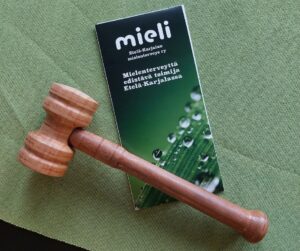 pöydällä puheenjohtajan nuija ja mieli e-K:n esite