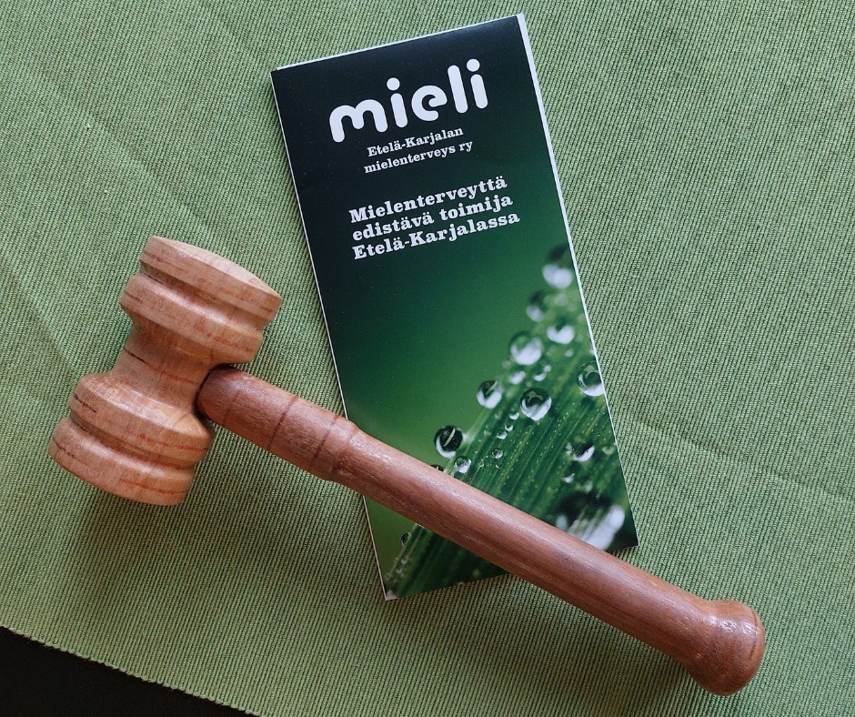 pöydällä puheenjohtajan nuija ja mieli e-K:n esite