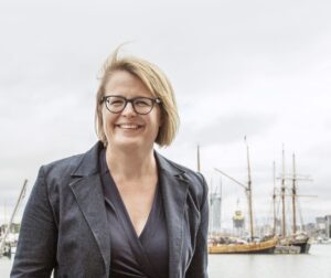 Sanna Vesikansa, puolivartalokuva, taustalla satamaa