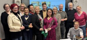 Ryhmäkuvassa tilaisuuden panelistit ja osanottajia