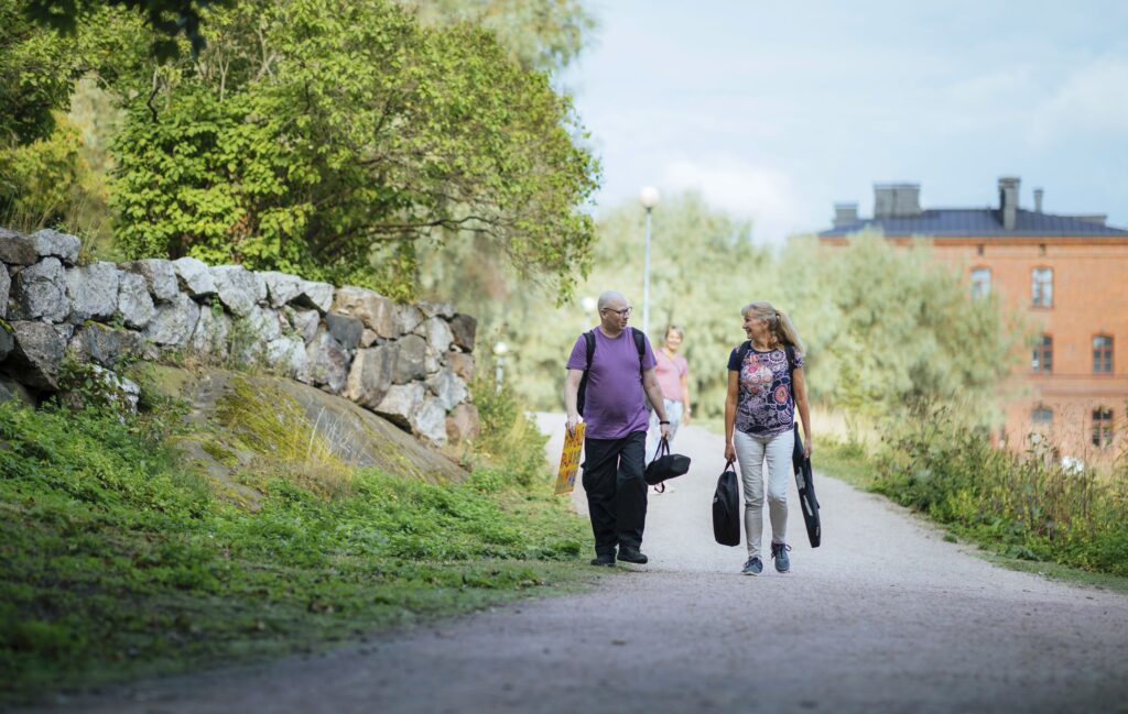 Kaksi ihmistä kävelee Lapinlahden rannassa.