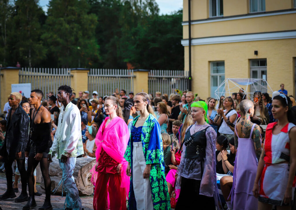 Kirkkaisiin väreihin pukeutuneita ihmisiä joukkona
