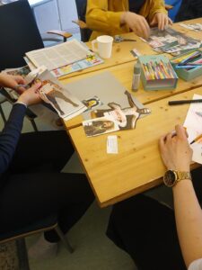 hands of people cutting out images from a magazine