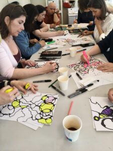 People sitting at a table drawing neurograph trees with markers and highlighters