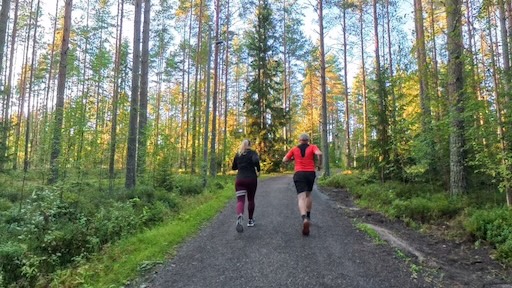 Kaksi lenkkeilijää metsässä