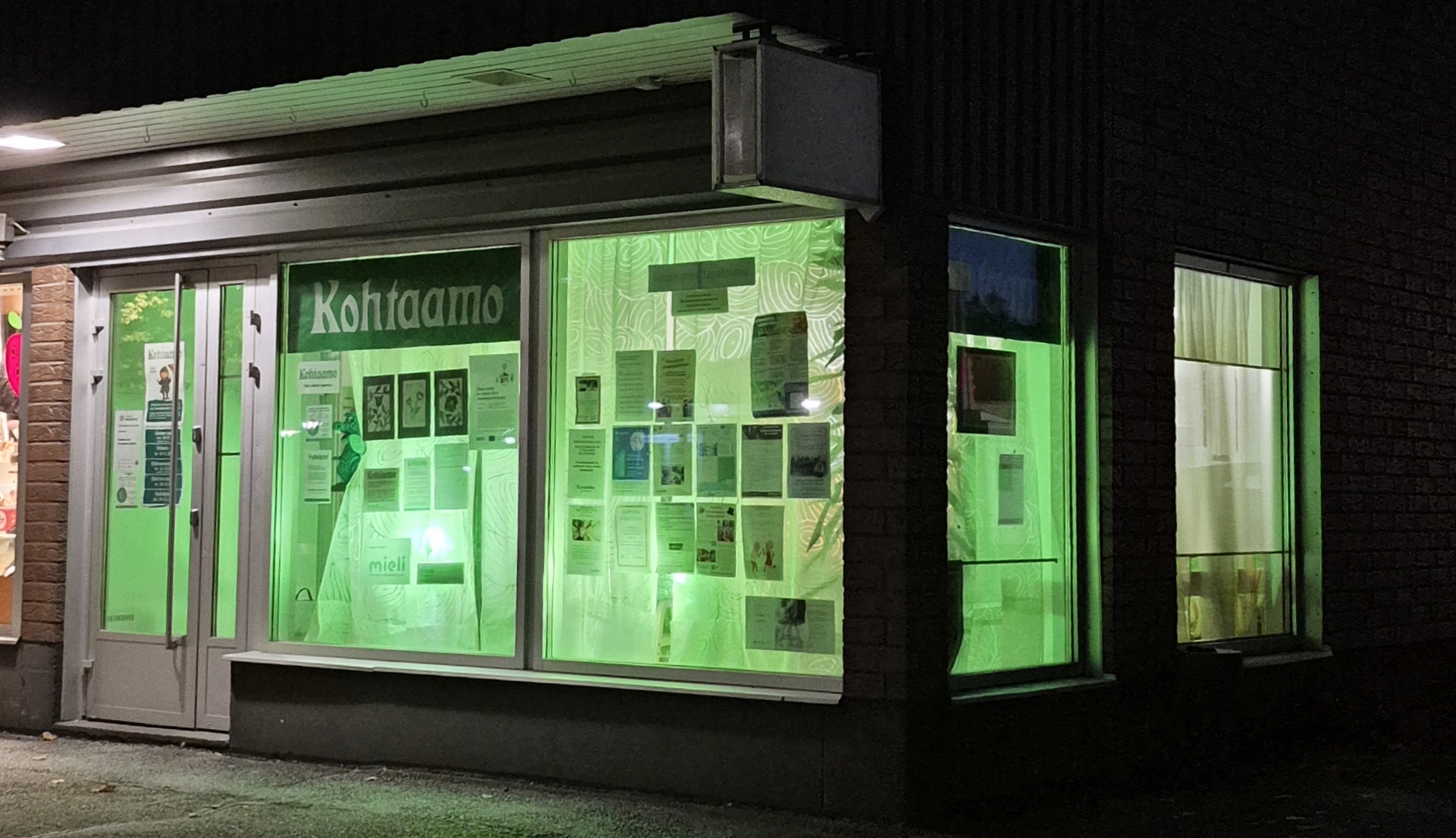Suonenjoen Kohtaamo valaistuna vihreällä valolla